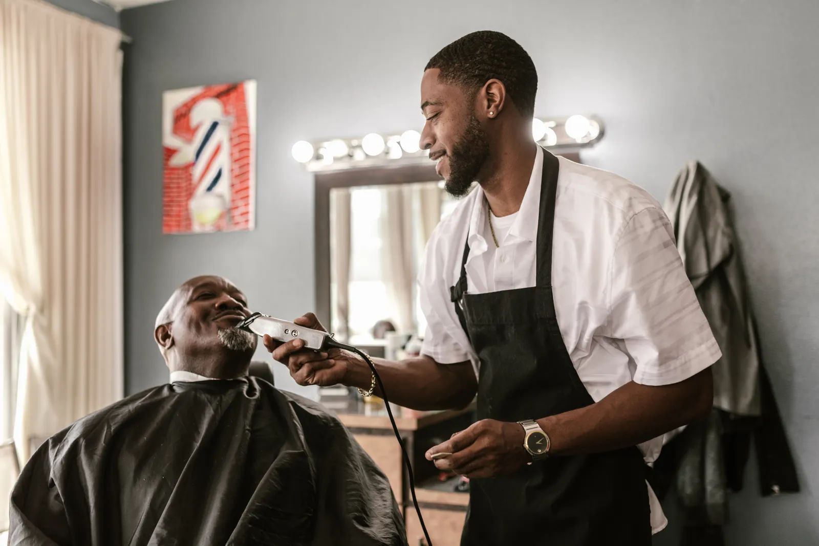 Barber trimming a client's beard in the shop